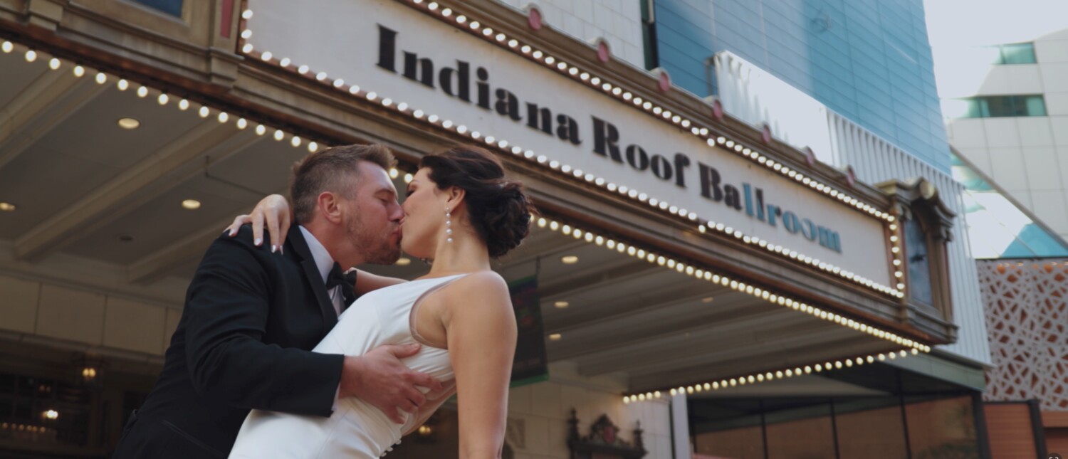 bride and groom kissing in front of the indiana roof ballroom